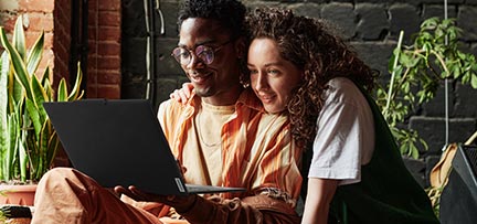 Two people looking at a Lenovo laptop 